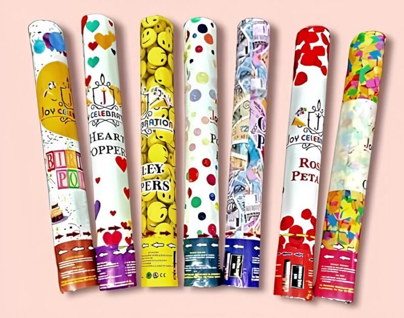 A close-up of seven individual 30cm party poppers assorted with different designs, including smiley faces, hearts, and confetti patterns.