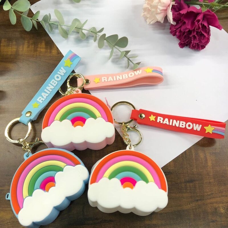 Rainbow Silicone Keychain Pouch featuring colorful arcs and white clouds, attached to keyrings with straps in various colors (blue, pink, red).