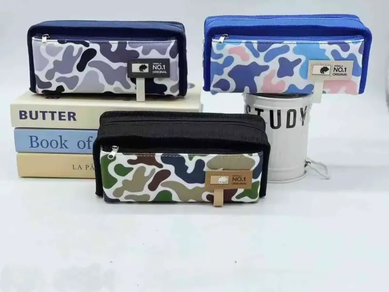 Three Military Pouches in different camouflage patterns (blue/grey, black/green, purple/grey) are displayed, stacked on books on a white surface.