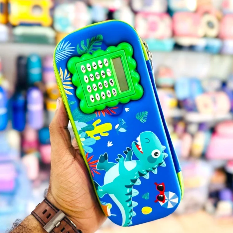 A hand holding a blue Pencil Pouch with Calculator featuring a dinosaur theme and a green built-in calculator.