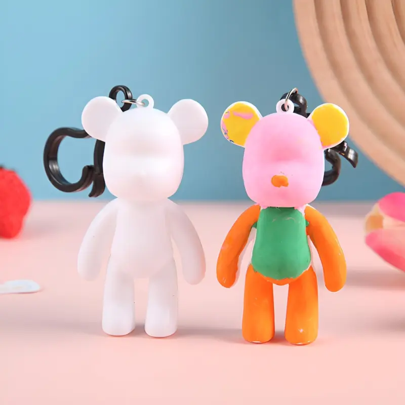 A white unpainted DIY Coloring Keychain figure next to a partially painted figure, demonstrating the coloring process and vibrant results.