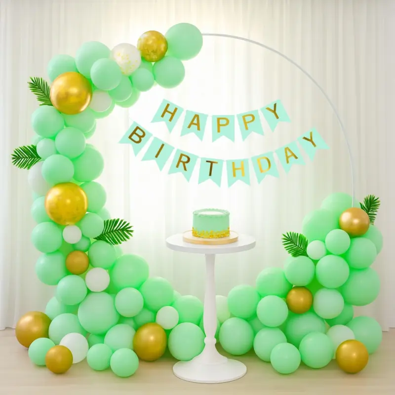 A beautifully arranged balloon arch made from the Pastel Green Birthday Decor Kit, featuring various sizes of pastel green, white, and gold balloons, with the green "Happy Birthday" V-cut banner prominently displayed.